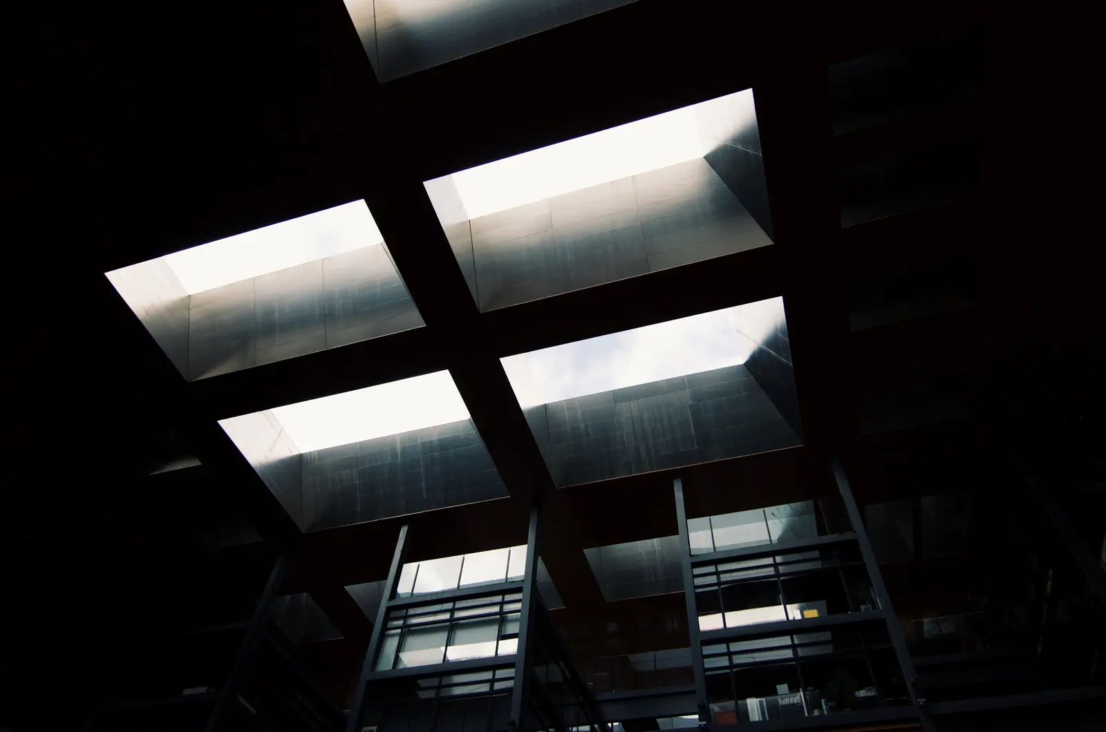 A dark coffered ceiling with recessed skylights.