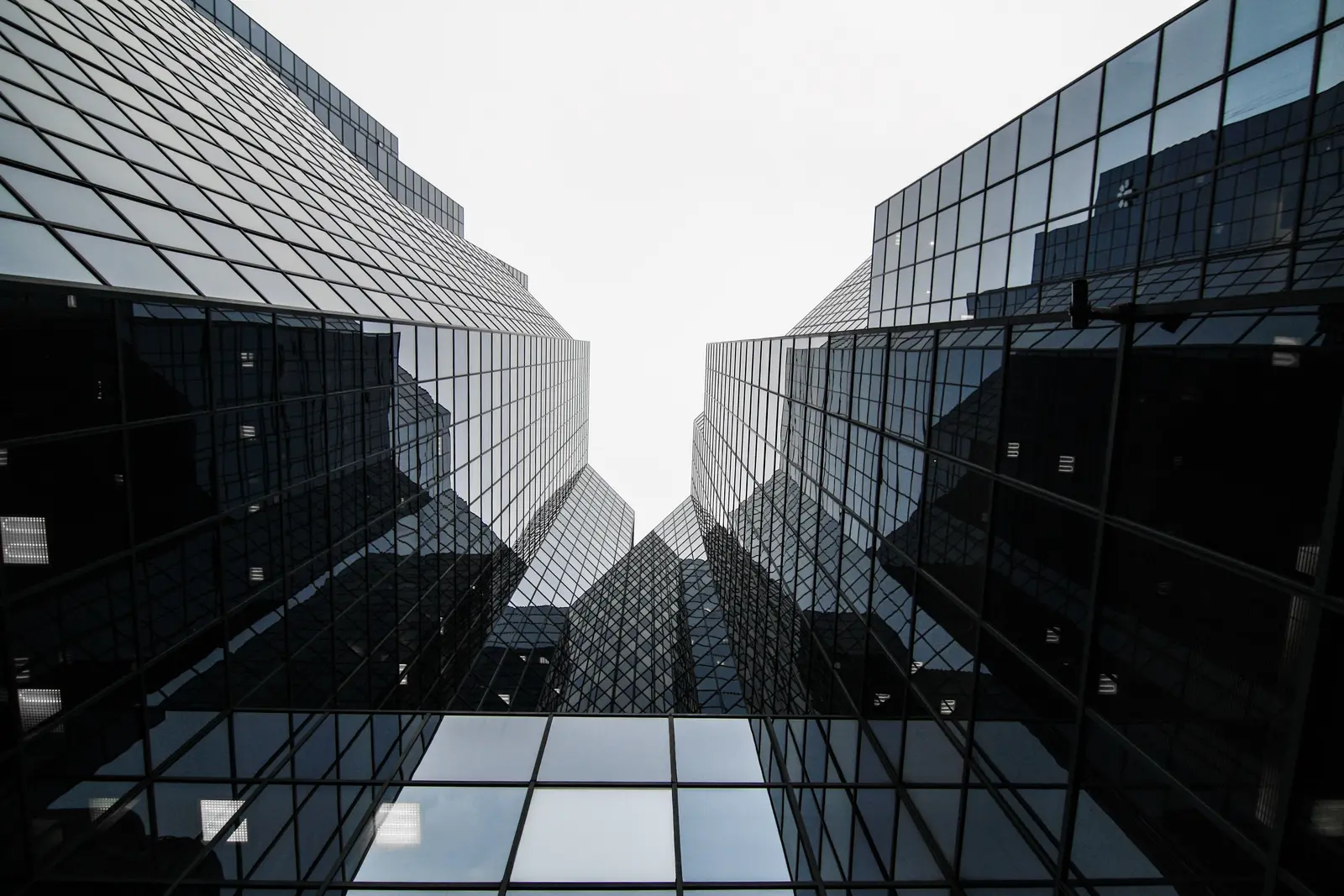 A dark glass tower reflecting the buildings around it.
