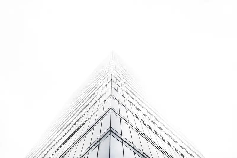 An office tower rising into mist until it disappears.